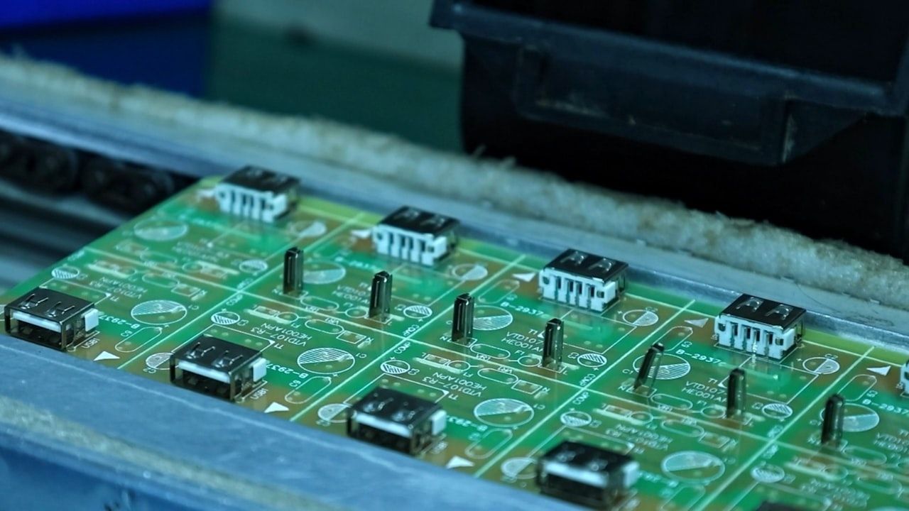 Panelised printed circuit boards moving along an assembly line